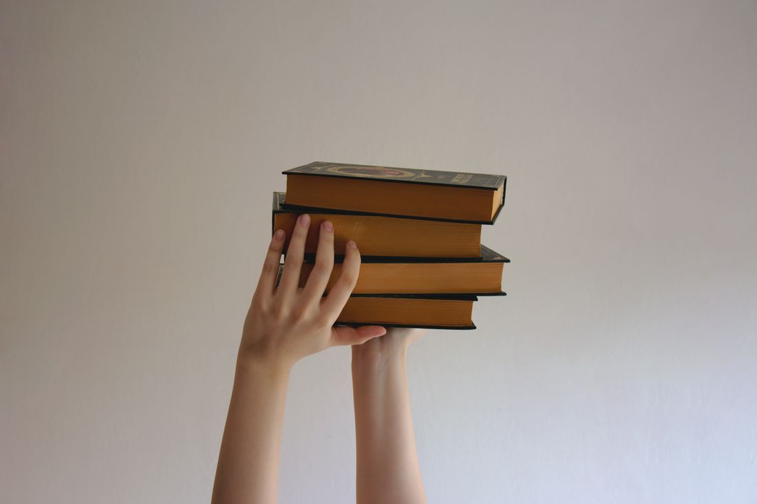 Buku kamus tebal terbuka di atas meja kayu