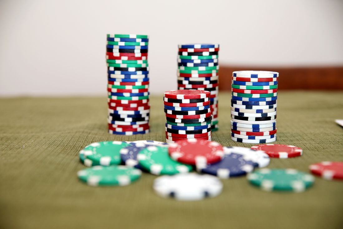 Chip poker tersusun di atas meja kartu